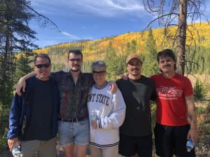 Kate McDermont and her family smiling in front of a beautiful fall landscape