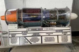 A 1/4-scale model of a J-57 engine with a clear housing and viewable internal components.