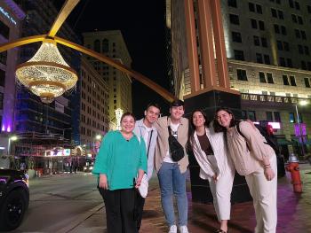 Asadbek Masharipov getting a photo taken with others with a city in the background. 