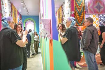 People standing in an exhibition looking at artwork.