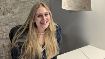 Young alumna sitting at a desk