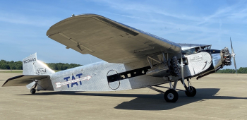 A large vintage aircraft with three large motors and a single high wing.
