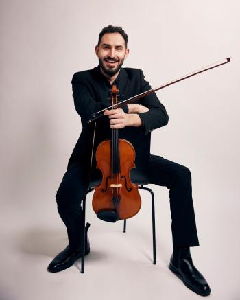 Portrait of Gabriel Napoli; sitting in a chair holding viola