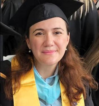 Gunel Alasgarova in a cap and gown with a light blue master's stole.