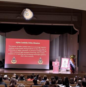 Alpha Lambda Delta President speaks onstage at induction ceremony.
