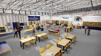 A computer render of the insode of a large hangar with tables, chairs, and cabinets for tools.