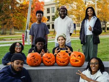 Toby and members of NOMAS pose with carved pumpkins.