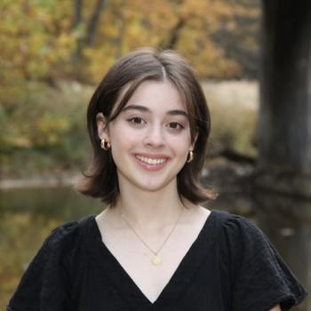 Headshot of Olivia Montagna with fall scenery blurred in the background