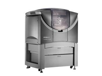 A very large 3d printer housed in a dark silver cabinet