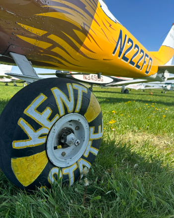 A close up view of an airplane wheel that is painted to include the words "Kent State"