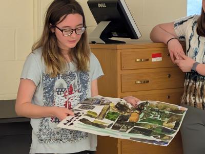 A student holds a personalized map she created.