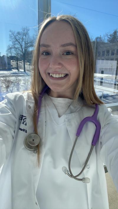 Halle outside, wearing her white nurse's coat.