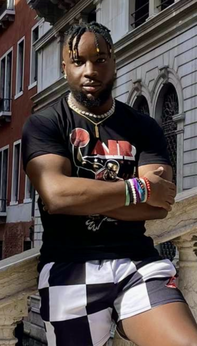 Joshua Daniel standing on a bridge in front of a white building