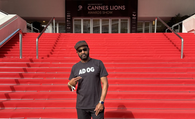 Lewis Williams standing in front of red carpet stairs with a banner behind him that reads Cannes Lions Awards Show