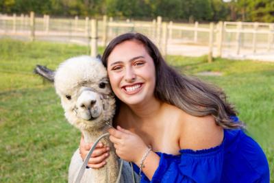 Honors College student Simone Herro poses with an alpaca.