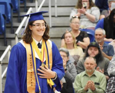 Honors College student Marshall Hall walks in cap and gown at high school graduation.