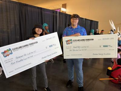 Two scholarship recipients pose with oversized Cleveland Gaming Foundation checks at the Cleveland Gaming Classic.