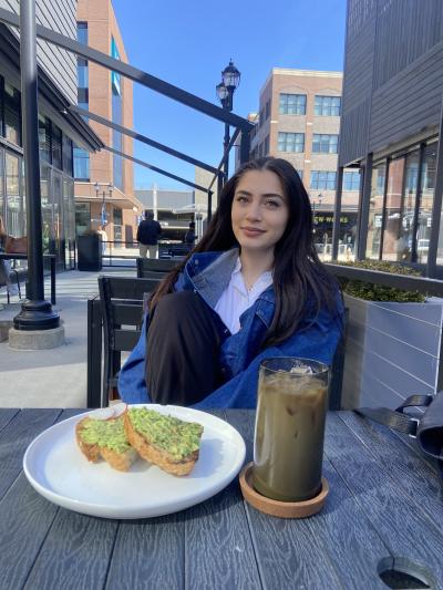Honors Student Sophia Daher sitting at a table enjoying a meal.