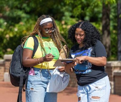 Two students looking down at a clipboard during the UGC Voting Drive