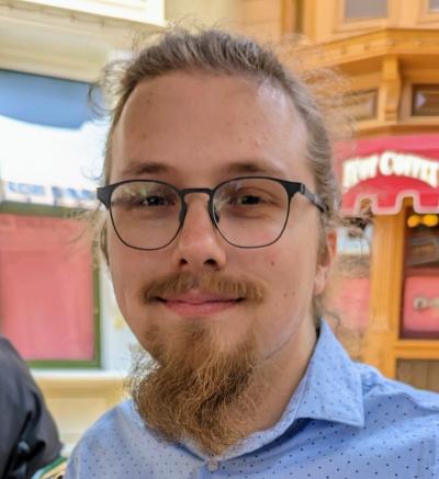 Nicholas Baird in a blue shirt, and glasses