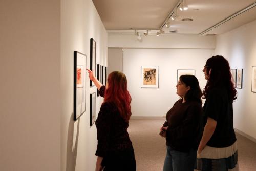 Student points at LeRoy Neiman artwork for other students to see