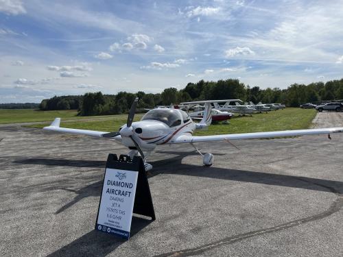 A small, single engine propeller aircraft parked on an airstrip.
