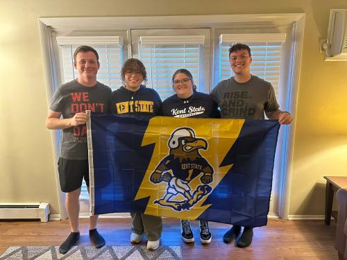 Kennedy with friends holding a Kent State flag