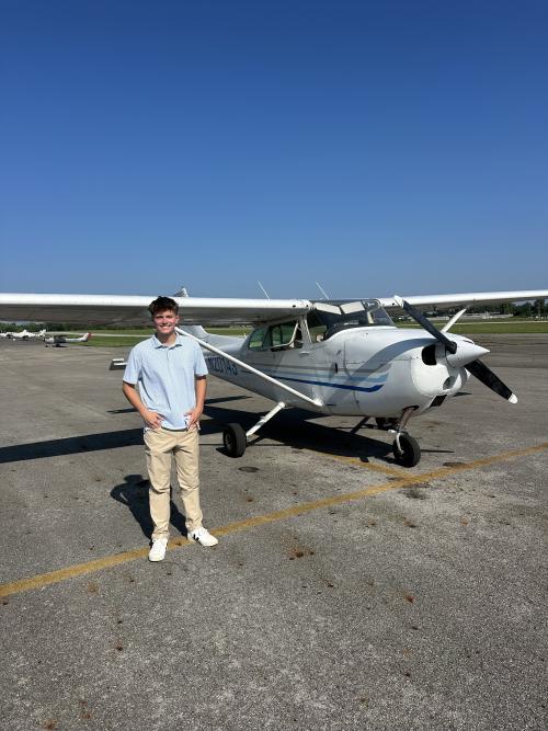 Zayden at the Kent State Airport, standing next to a plane.