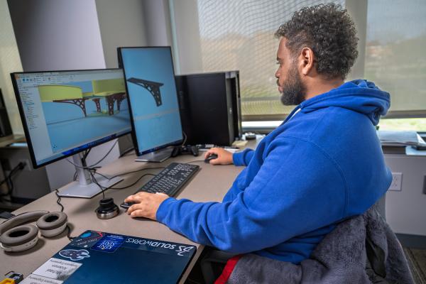 Student designing on a computer in the Digital Engineering Design Center