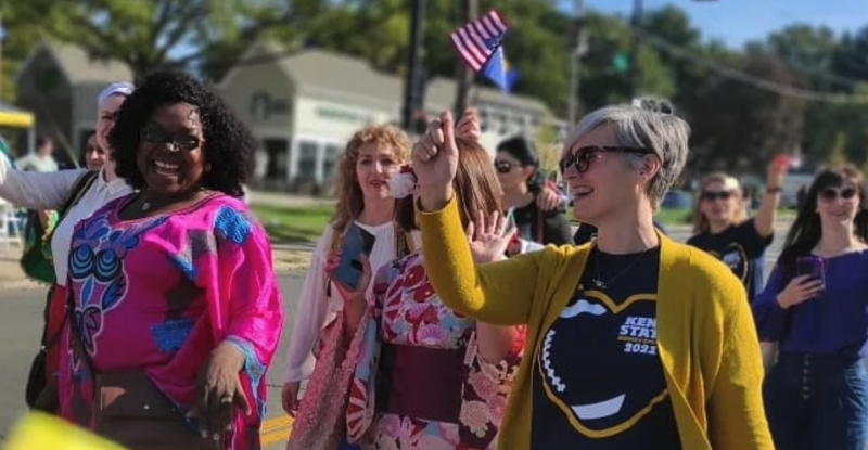 Gerald H. Read Center director, Amanda Johnson, holding an American flag as she walks with other members of the community in the Homecoming parade on the Kent campus.