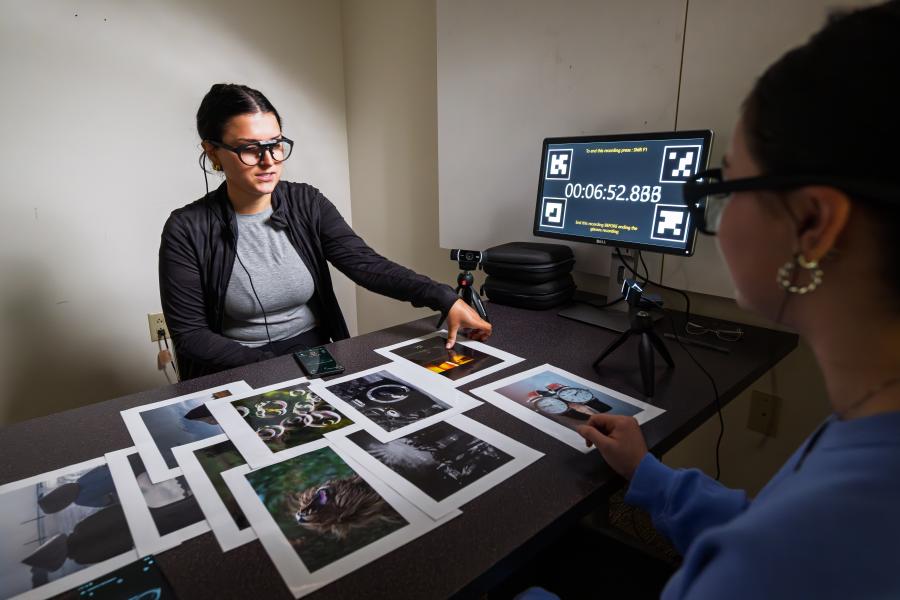 A student wears high tech eyeglasses with abstract photographs in front of her.