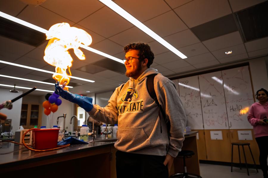 A student in a lab holds fire in his hands.