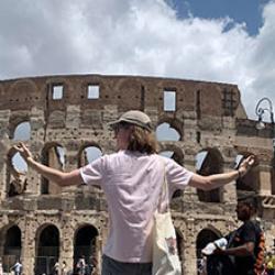 Kris holding up his arms in front of the Colosseum in Rome.