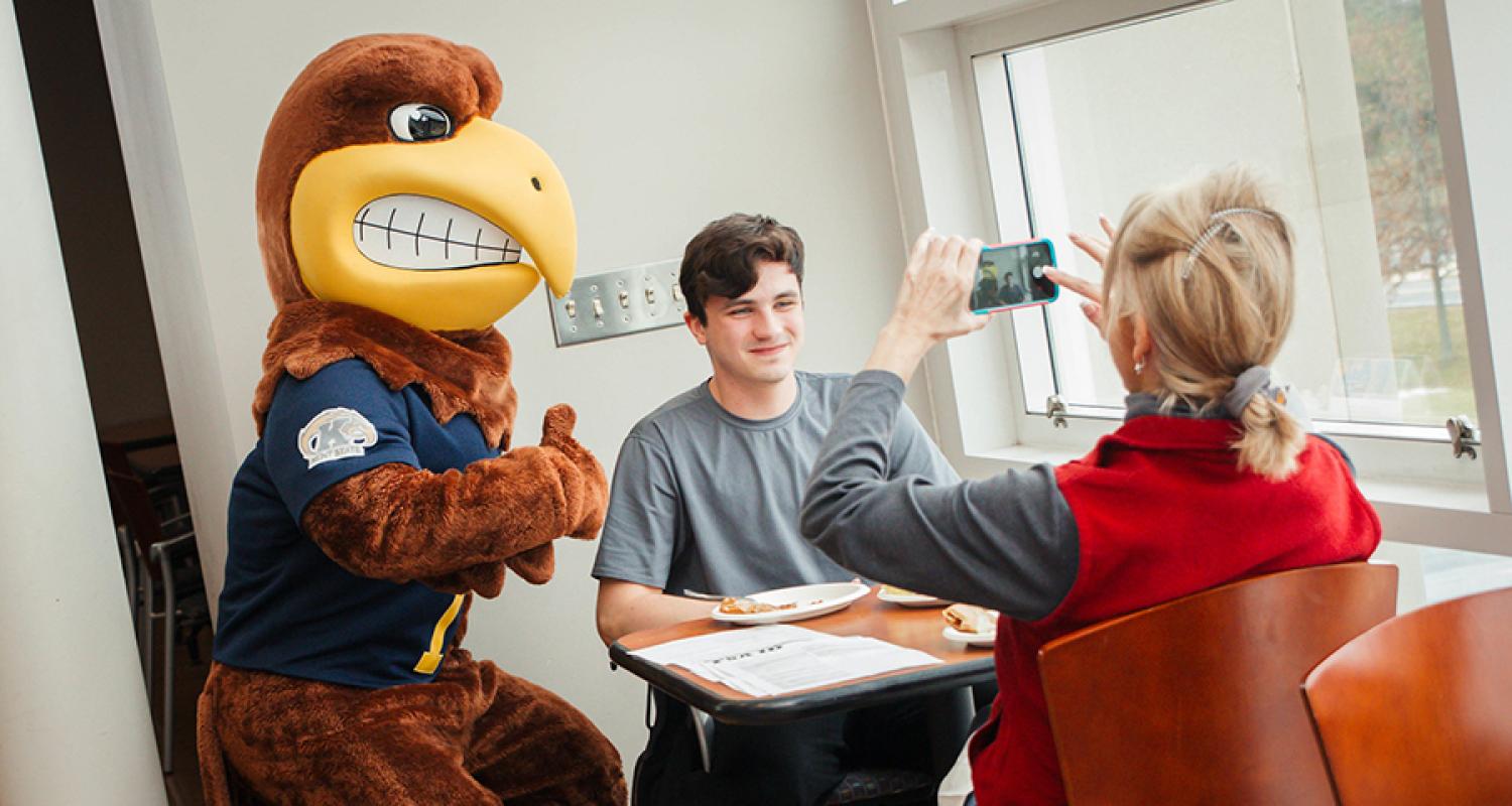 A parent takes a photo of her son next to Flash