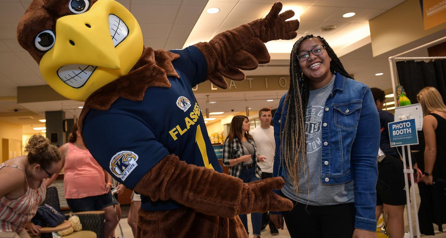 Flash poses for a picture with a student.