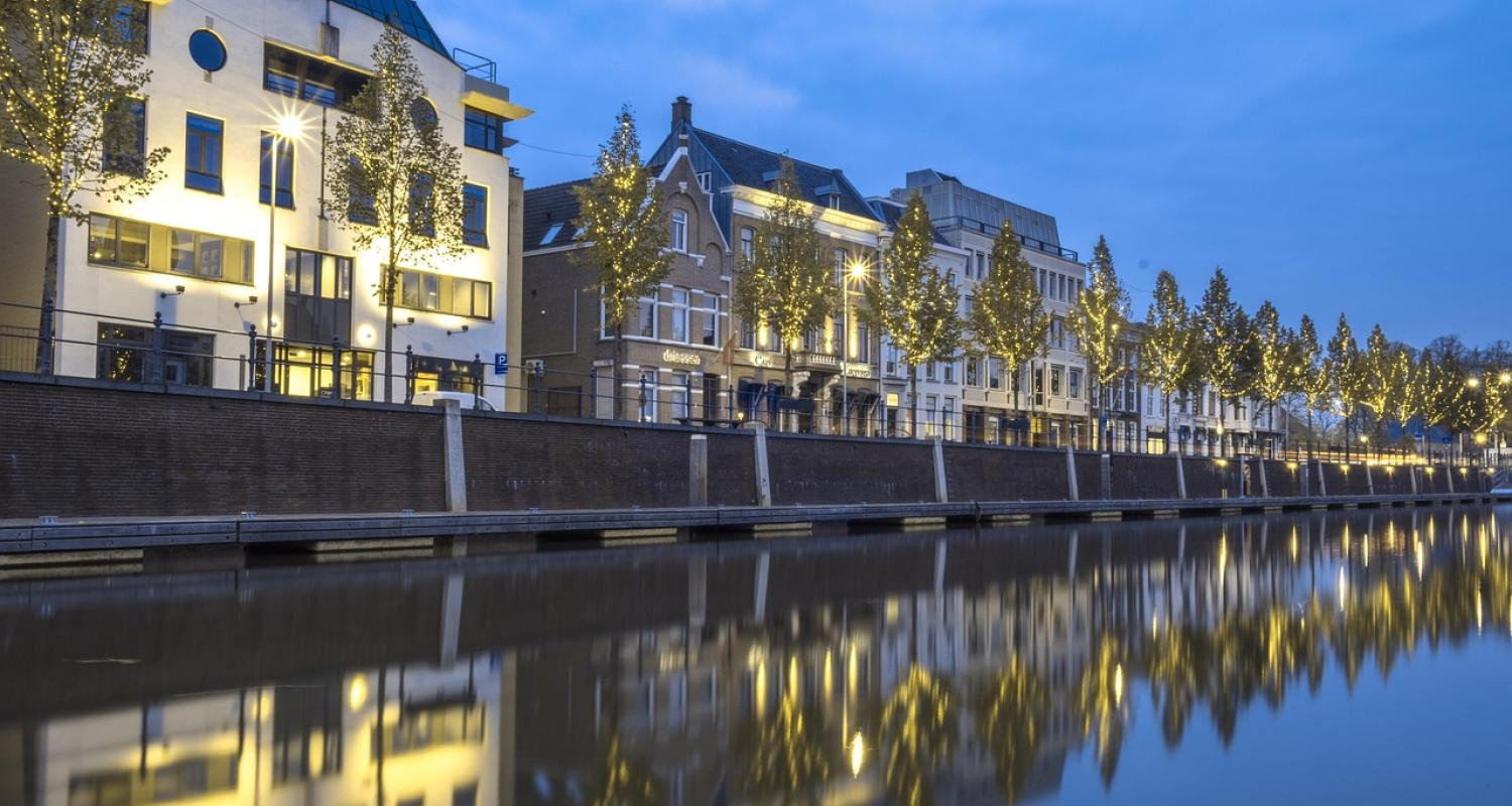 Buildings lit up at night on a river