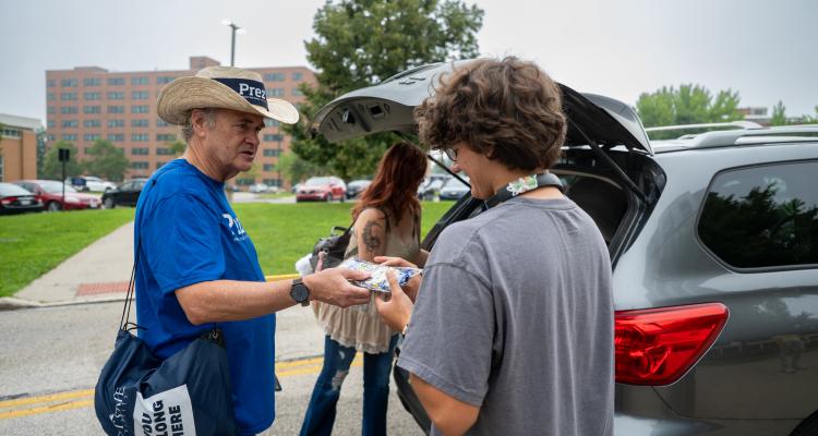 �Ը������� President Todd Diacon hands a pair of �Ը�������-branded socks to a student during Move-In.
