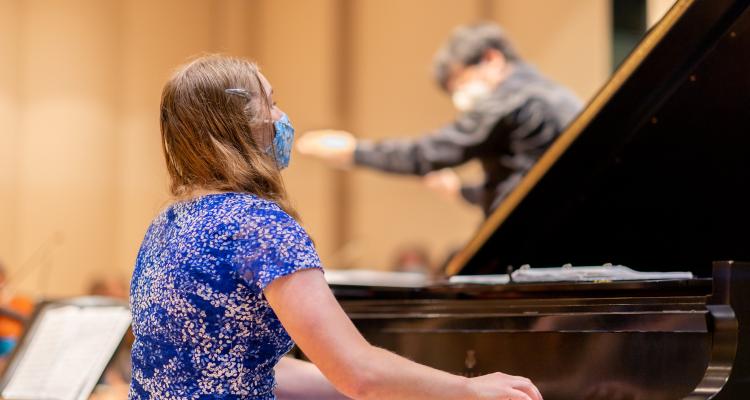 Alena plays the piano while rehearsing with the Severance Hall orchestra for the 鶹ý May 4th remembrance concert.  