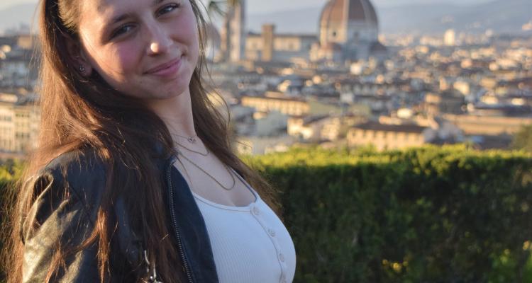 Melissa Williams standing outdoors with a city skyline behind her
