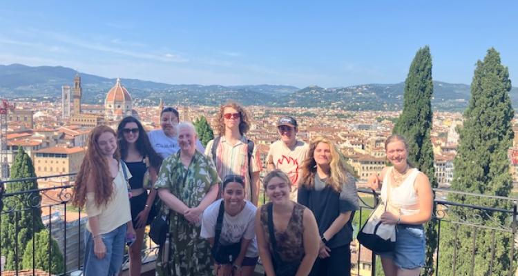 Cone and her students in the Rose Garden in Florence with a view of the city behind them.