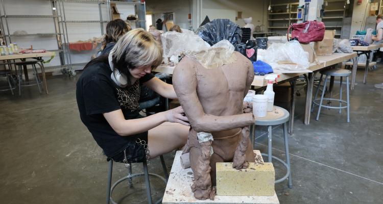 Artist sculpts a sculpture with clay