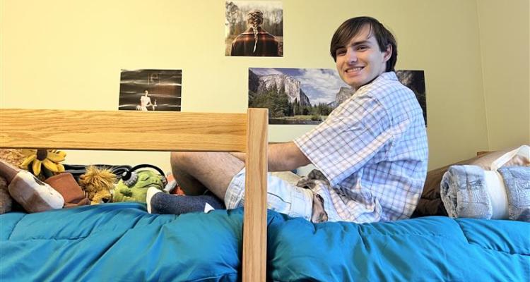 Honors student Lucas Hlavacek sittings in his residence hall room at .