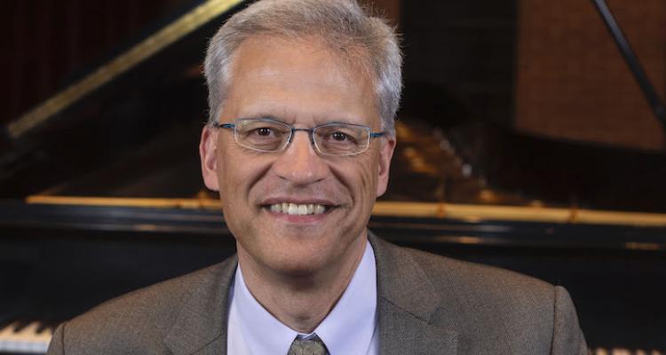 Kent McWilliams headshot in Ludwig Recital Recital in front of Steinway grand piano