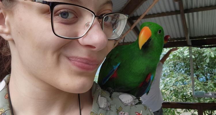 Honors student Maddison Evans poses with a bird during study abroad trip.