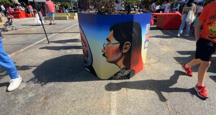 Image of a planter pot with art by Nick Lee on it