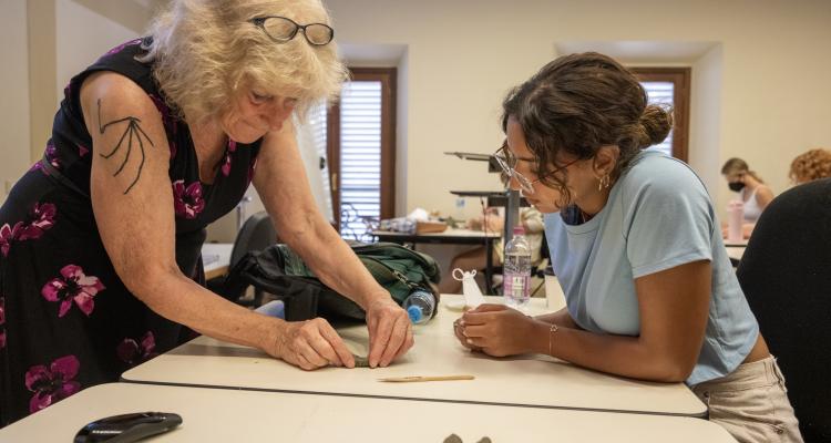 Dr. Spurlock helping a student shape clay.