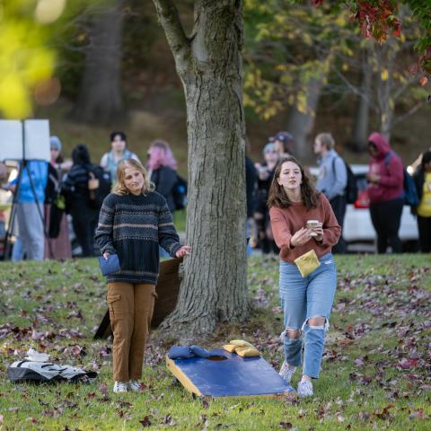 Two students playing cornhole during a fall festival at Kent State University.