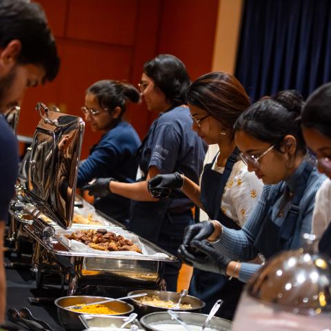 Students from different countries serve food to guests during the International Cook-Off at Kent State.