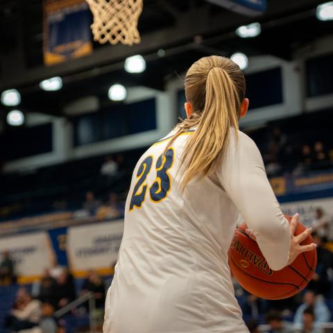 A Kent State women’s basketball player wearing jersey No. 23 holds the ball near the basket during a game at the MAC Center.