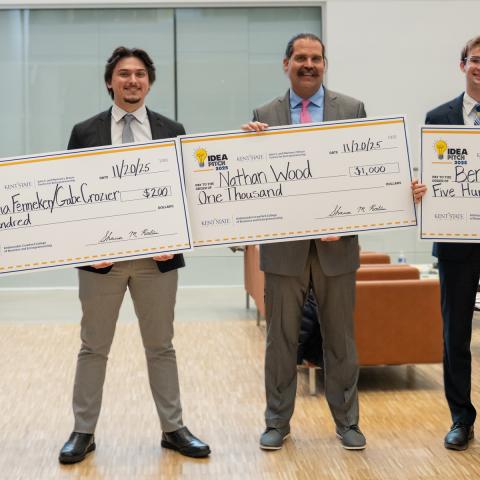 winnners of the 2025 idea pitch, posing with their advisors and large checks. 